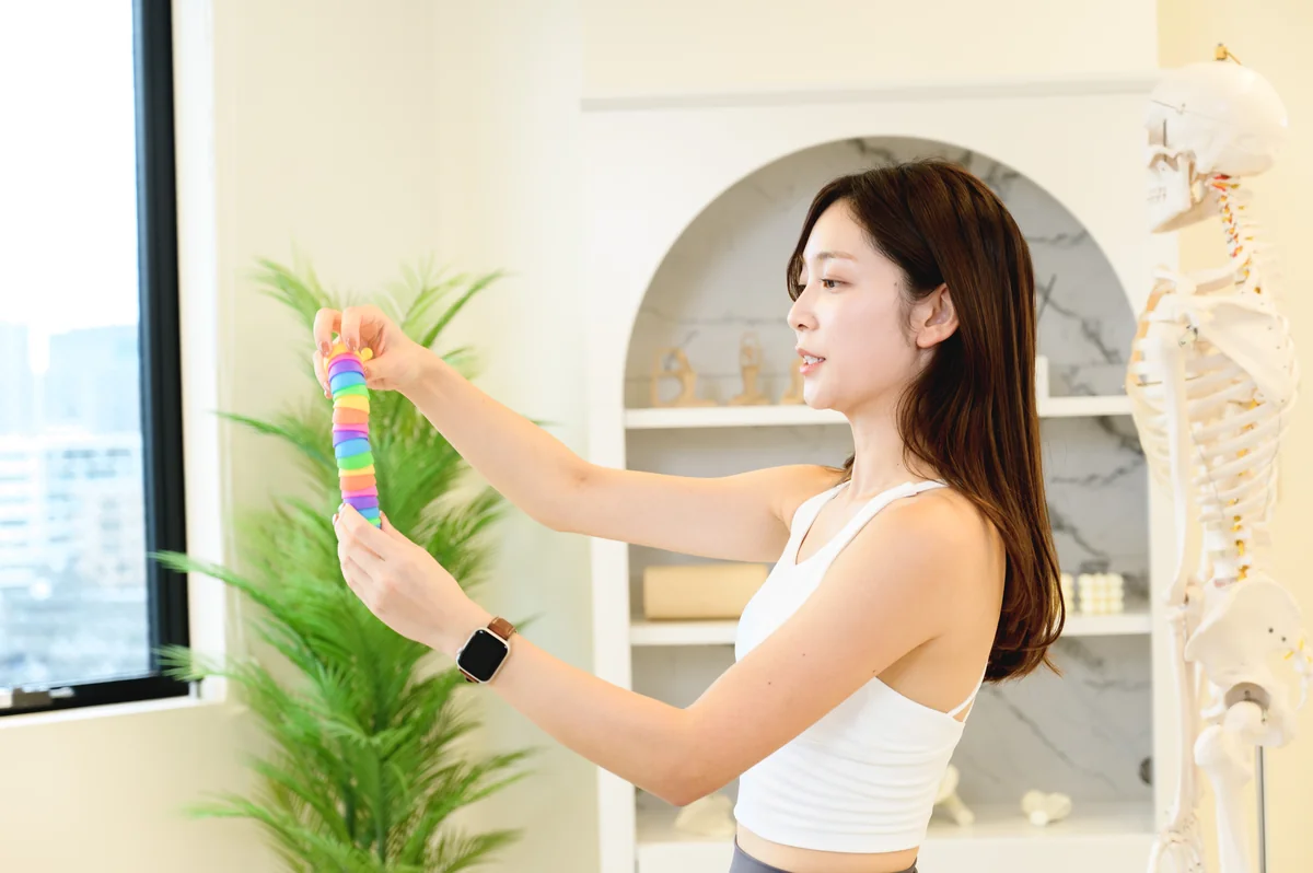 背骨の模型を手に、体の動きを説明する講師